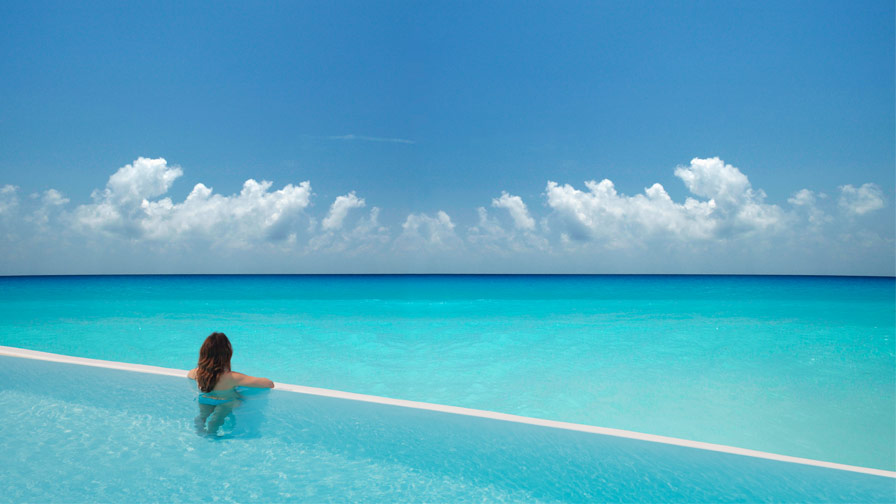 Woman in pool overlooking ocean in Barbados