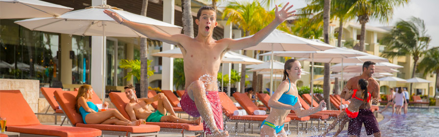 Guests jumping in the pool at all-inclusive Palace Resorts