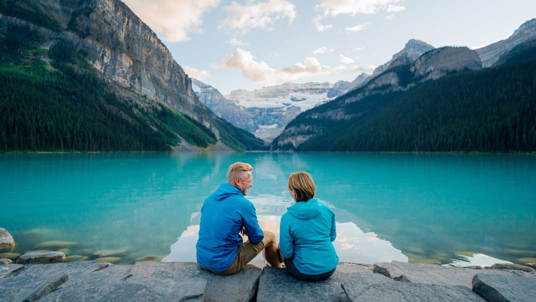 Couple sitting on dock overlooking a mountain lake