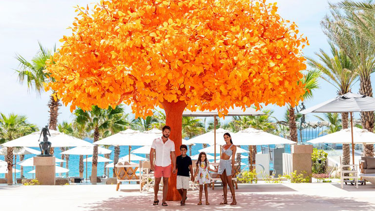 Family standing by orange tree at Garza Blanca Resort and Spa Los Cabos