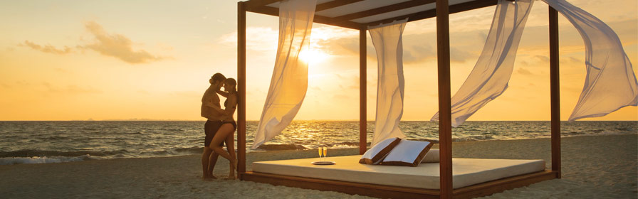 Un couple enlacé sur la plage au coucher du soleil 