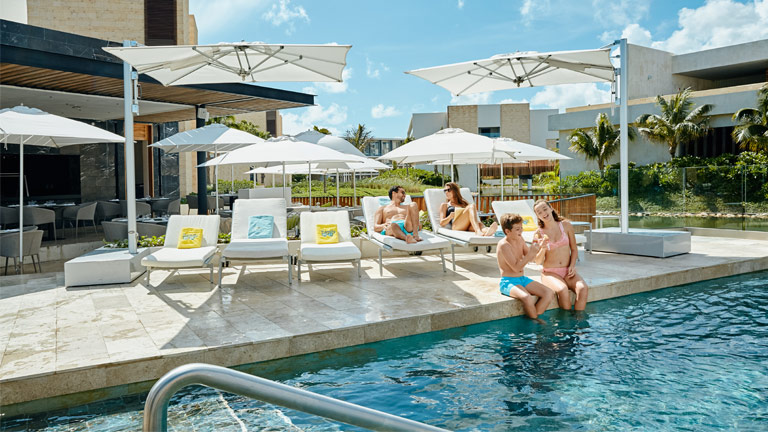 Une famille profite de la piscine pendant leurs vacances tout inclus au Grand Palladium Costa Mujeres Resort & Spa