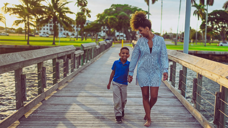 Mother and son walking along pier in Florida