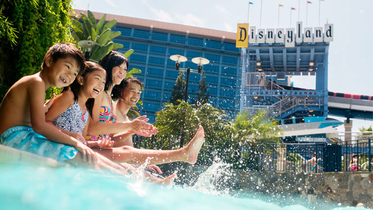 Une famille patauge dans la piscine du Disneyland Hotel