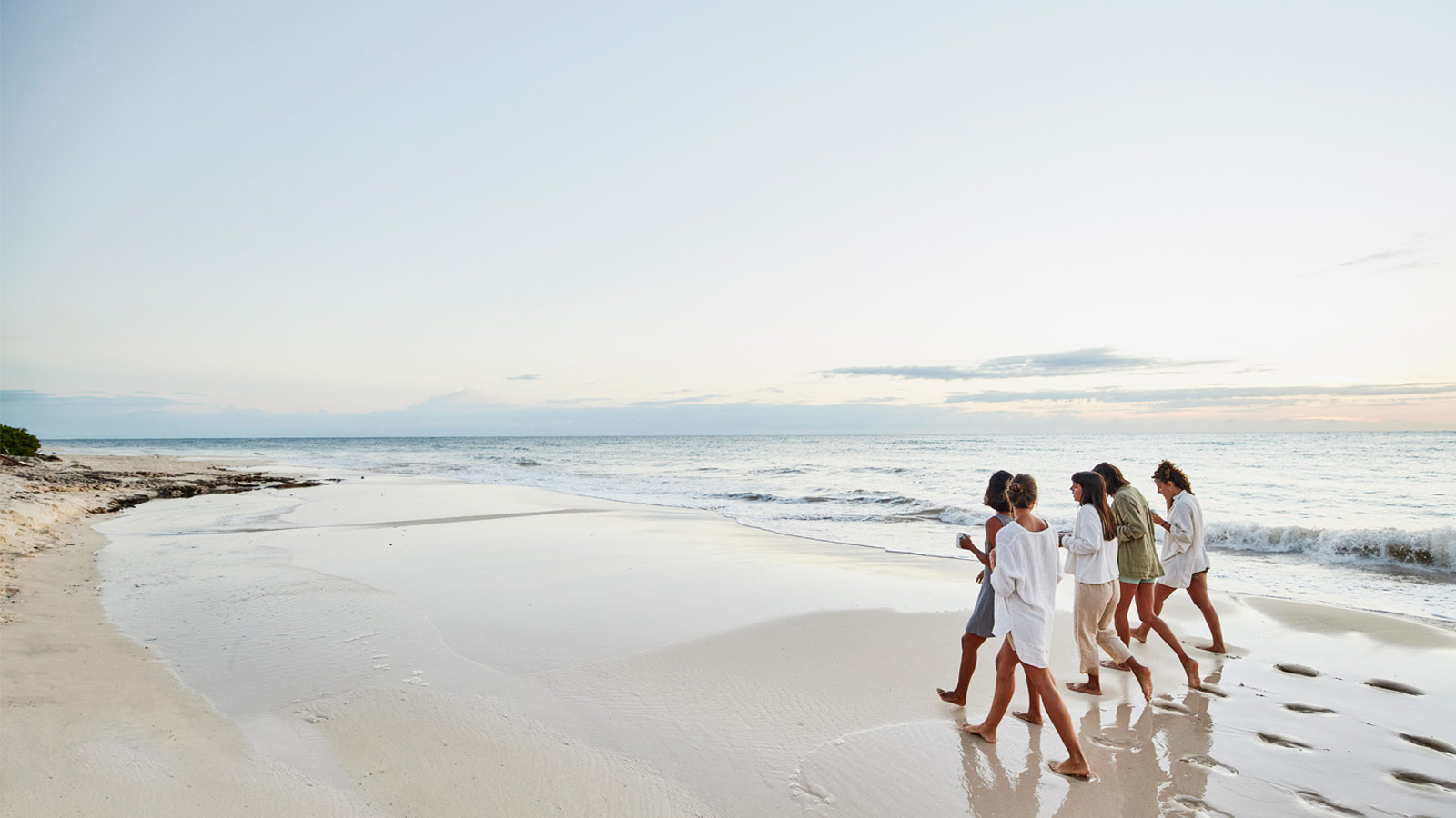 Des amis marchent sur une plage du Mexique pendant leurs vacances tout inclus