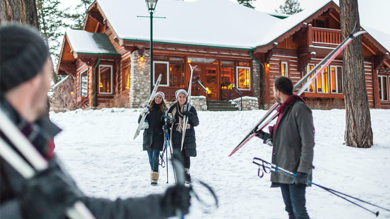 Friends carrying skis at Fairmont Jasper Park Lodge