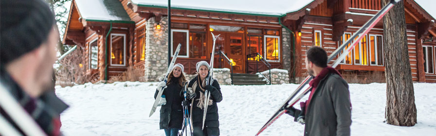 Friends carrying skis at Fairmont Jasper Park Lodge