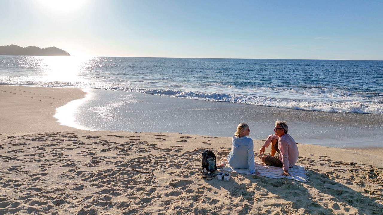 Couple sitting on Sayulita beach, Nayarit Mexico